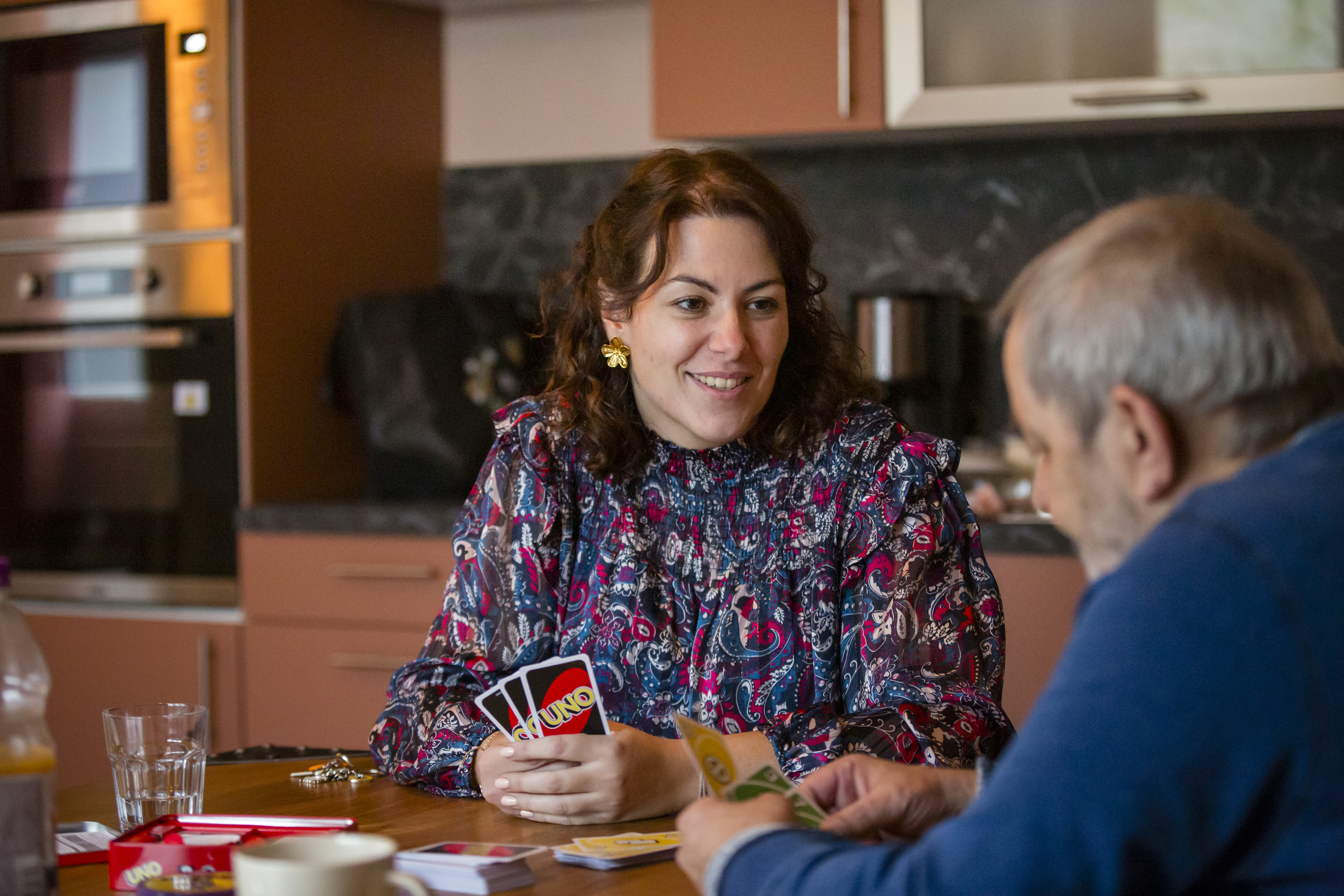 Une responsable de pension de famille joue aux cartes avec un résident
